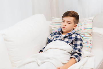 Image showing ill boy with flu lying in bed at home