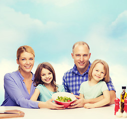 Image showing happy family with two kids with salad at home