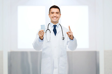 Image showing smiling male doctor in white coat with pills