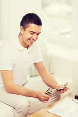 Image showing man with papers and calculator at home