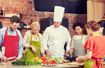 Image showing happy friends and chef cook cooking in kitchen