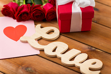 Image showing close up of gift box, red roses and greeting card