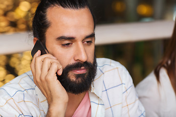 Image showing sad man calling on smartphone at restaurant