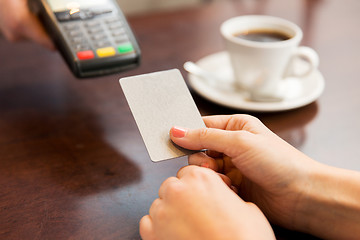 Image showing close up of hands with credit card reader at cafe