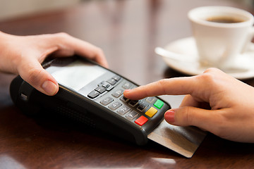 Image showing close up of hands with credit card reader at cafe