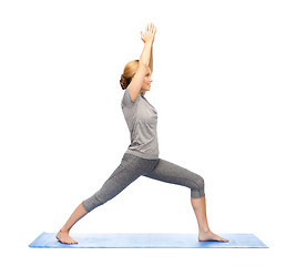 Image showing woman making yoga warrior pose on mat