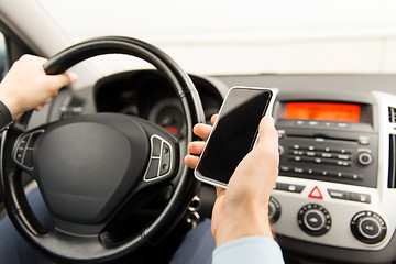 Image showing close up of man hand with smartphone driving car