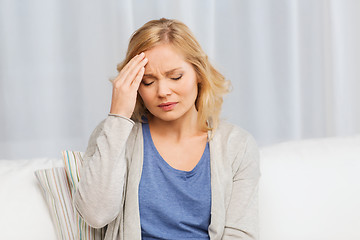 Image showing unhappy woman suffering from headache at home