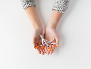 Image showing close up of woman hands holding syringes