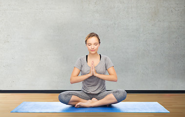 Image showing woman making yoga meditation in lotus pose on mat