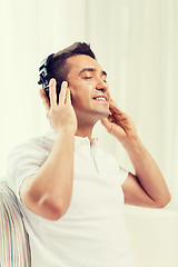 Image showing happy man in headphones listening to music at home