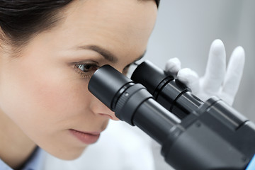 Image showing close up of scientist looking to microscope in lab