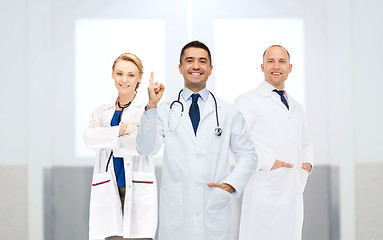 Image showing group of doctors at hospital pointing finger up