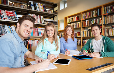 Image showing happy students writing to notebooks in library