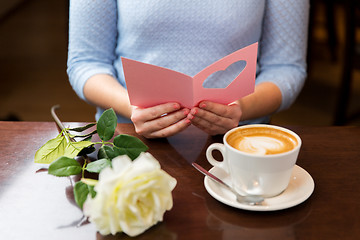 Image showing close up of woman reading greeting card and coffee