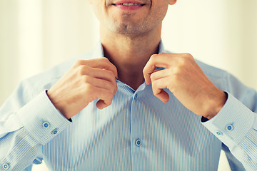 Image showing close up of smiling man in shirt dressing 