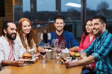 Image showing friends taking selfie by smartphone at restaurant