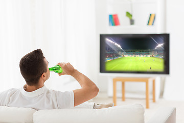 Image showing man watching football and drinking beer at home