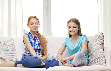 Image showing happy little girls sitting on sofa at home