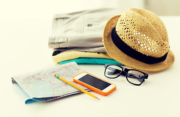 Image showing close up of summer clothes and travel map on table