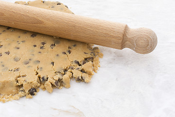 Image showing Wooden rolling pin on chocolate chip shortbread dough