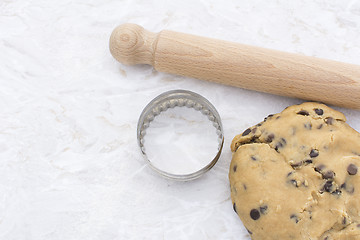 Image showing Chocolate chip cookie dough with rolling pin and cookie cutter 
