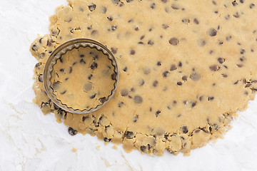 Image showing Cookie cutter on rolled out chocolate chip cookie dough