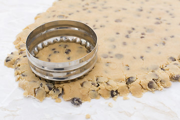 Image showing Cookie cutter cutting circle from cookie dough