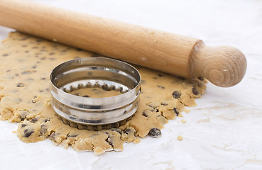Image showing Cookie cutter and rolling pin on cookie dough