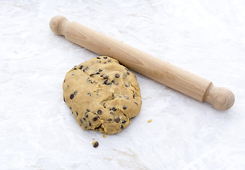 Image showing Ball of chocolate chip cookie dough with rolling pin