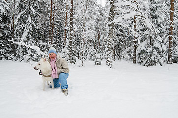 Image showing The woman with a dog on walk in a winter wood