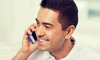 Image showing happy man calling on smartphone at home