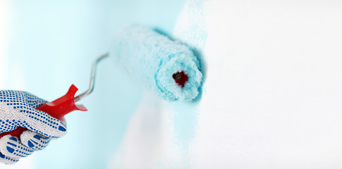 Image showing close up of male in gloves painting wall