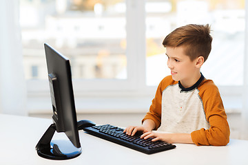 Image showing smiling boy with computer at home