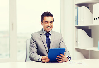 Image showing smiling businessman with tablet pc in office