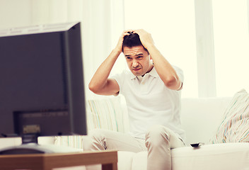 Image showing disappointed man watching tv at home