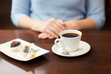 Image showing close up of woman hands with coffee and dessert