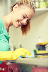 Image showing happy woman cleaning cooker at home kitchen
