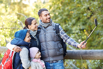 Image showing happy family with smartphone selfie stick in woods