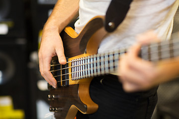 Image showing close up of musician with guitar at music studio