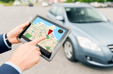 Image showing close up of hands with gps on tablet pc and car