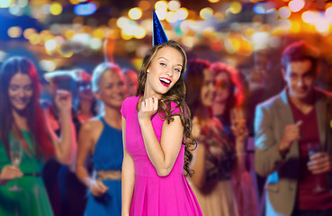 Image showing happy woman or teen in party cap at night club