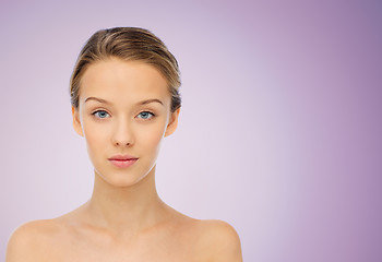 Image showing young woman face with bare shoulders over violet