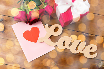 Image showing close up of gift box, red roses and greeting card