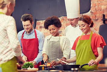 Image showing happy friends and chef cook cooking in kitchen