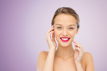 Image showing smiling young woman with pink lipstick on lips