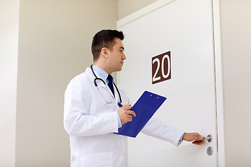 Image showing doctor with clipboard opening hospital ward door