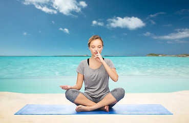 Image showing woman meditating in lotus yoga pose on beach