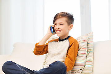 Image showing happy boy calling on smartphone at home