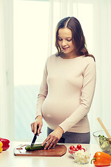 Image showing happy pregnant woman preparing food at home